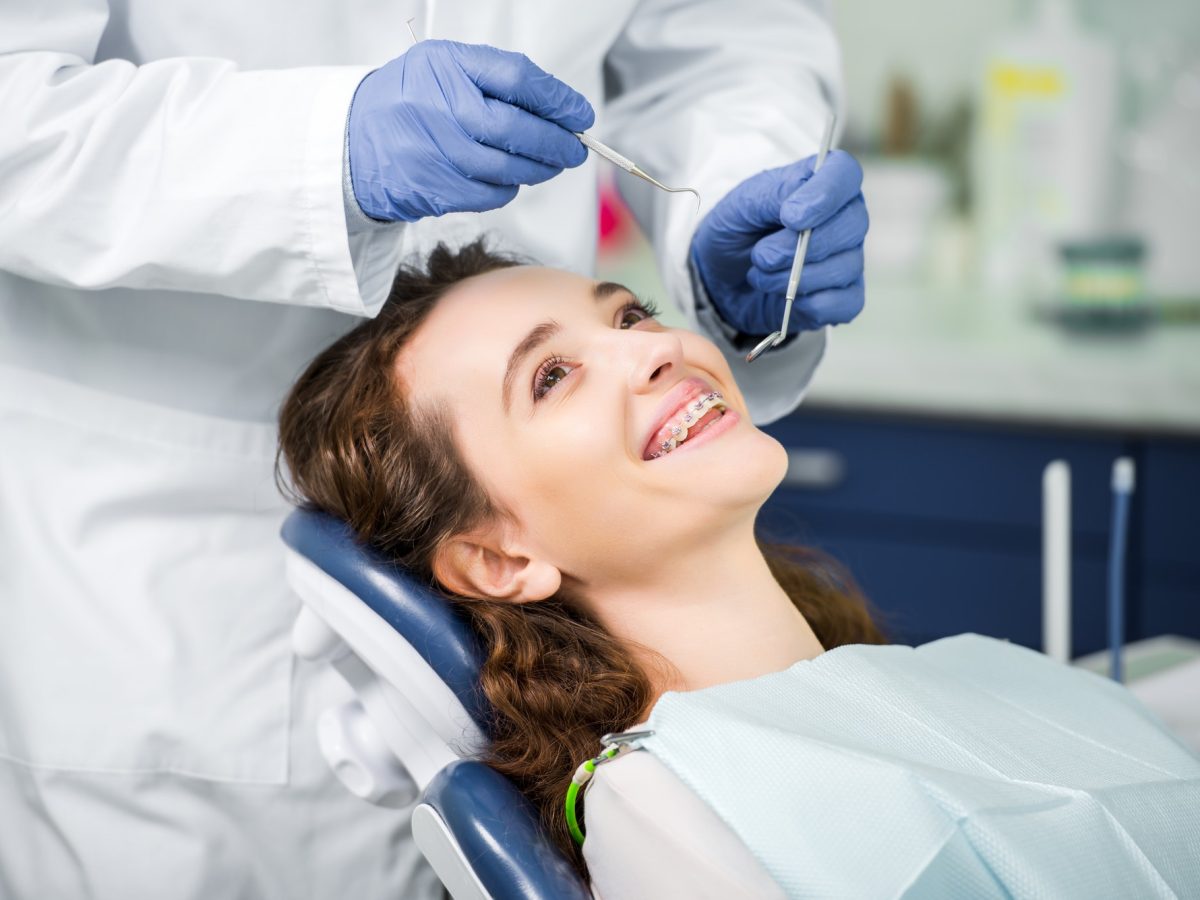 cropped-view-of-dentist-in-latex-gloves-examining-cheerful-woman-in-braces.jpg